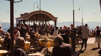 Movie still from “The Godfather Part II” (1974), directed by Francis Ford Coppola – A group of people sitting at tables outside of a building; Extreme Wide shot, High angle