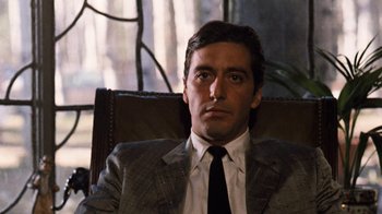 Movie still from “The Godfather Part II” (1974), directed by Francis Ford Coppola – A person wearing a suit and tie; Close Up shot, Low angle