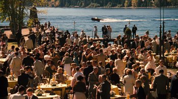 Movie still from “The Godfather Part II” (1974), directed by Francis Ford Coppola – A crowd of people standing on a pier near a body of water; Extreme Wide shot, High angle