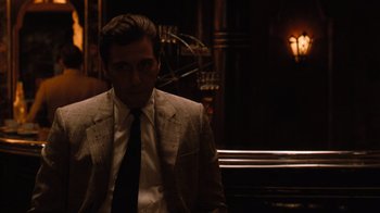 Movie still from “The Godfather Part II” (1974), directed by Francis Ford Coppola – A man wearing a suit and tie standing in a room; Medium shot, Low angle