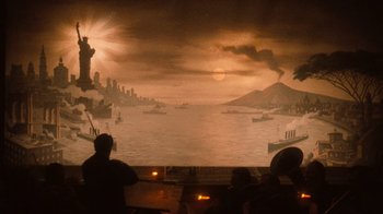Movie still from “The Godfather Part II” (1974), directed by Francis Ford Coppola – People are sitting in front of a large painting of a city; Extreme Wide shot, High angle