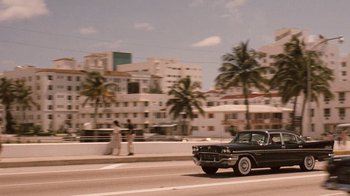 Movie still from “The Godfather Part II” (1974), directed by Francis Ford Coppola – A car driving down a street past palm trees; Extreme Wide shot, Over the shoulder angle