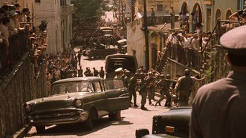 Movie still from “The Godfather Part II” (1974), directed by Francis Ford Coppola – An old car is parked on the side of the street; Extreme Wide shot, High angle