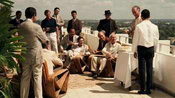 Movie still from “The Godfather Part II” (1974), directed by Francis Ford Coppola – A group of men sitting on top of a building; Wide shot, Over the shoulder angle