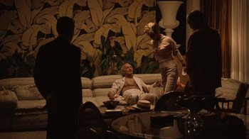 Movie still from “The Godfather Part II” (1974), directed by Francis Ford Coppola – A man and a woman sitting on a couch in a living room; Wide shot, Over the shoulder angle