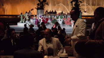 Movie still from “The Godfather Part II” (1974), directed by Francis Ford Coppola – Two men are sitting at a table in front of a crowd; Extreme Wide shot, Over the shoulder angle