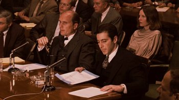 Movie still from “The Godfather Part II” (1974), directed by Francis Ford Coppola – A group of people sitting at a table; Medium shot, Over the shoulder angle