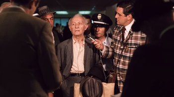 Movie still from “The Godfather Part II” (1974), directed by Francis Ford Coppola – An old man is being interviewed by a group of men; Medium shot, Over the shoulder angle