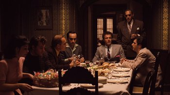Movie still from “The Godfather Part II” (1974), directed by Francis Ford Coppola – A group of men sitting at a table with food on it; Wide shot, High angle