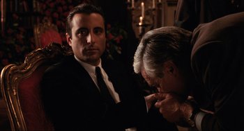 Movie still from “The Godfather Part III” (1990), directed by Francis Ford Coppola – A man in a black suit and a man in a white shirt and black tie; Medium shot, Over the shoulder angle