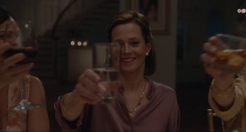 Movie still from “The Good House” (2021), directed by Maya Forbes – A woman holding up a glass of water in her right hand; Close Up shot, Over the shoulder angle