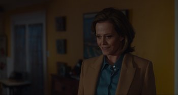 Movie still from “The Good House” (2021), directed by Maya Forbes – A woman wearing a brown jacket standing in a living room; Medium shot, Over the shoulder angle