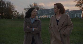 Movie still from “The Good House” (2021), directed by Maya Forbes – Two women standing in a grassy field near a house; Medium shot, Over the shoulder angle