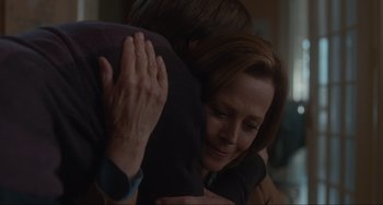 Movie still from “The Good House” (2021), directed by Maya Forbes – A woman hugging a man in a dark room; Close Up shot, Over the shoulder angle