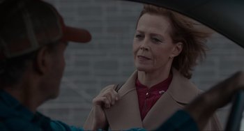 Movie still from “The Good House” (2021), directed by Maya Forbes – A woman in a red shirt and a brown coat; Close Up shot, Over the shoulder angle