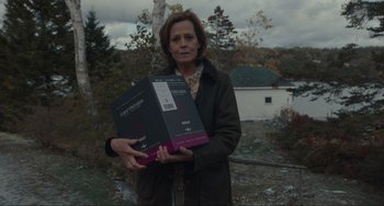 Movie still from “The Good House” (2021), directed by Maya Forbes – A woman holding two boxes in her hands; Medium shot, Over the shoulder angle