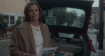 Movie still from “The Good House” (2021), directed by Maya Forbes – A woman standing in the back of a car holding papers; Medium shot, Over the shoulder angle