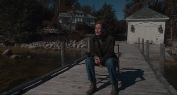 Movie still from “The Good House” (2021), directed by Maya Forbes – A man sitting on a chair on a dock; Wide shot, High angle