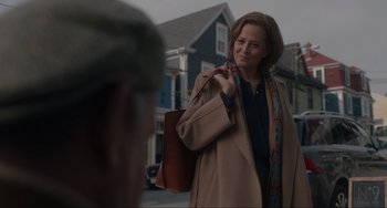 Movie still from “The Good House” (2021), directed by Maya Forbes – A woman in a trench coat holding onto a brown purse; Medium shot, Over the shoulder angle