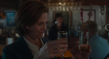 Movie still from “The Good House” (2021), directed by Maya Forbes – A woman sitting at a table holding a wine glass; Close Up shot, Over the shoulder angle