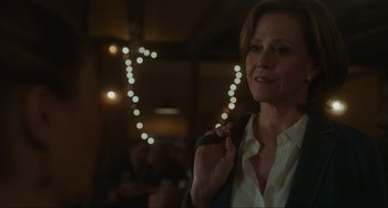 Movie still from “The Good House” (2021), directed by Maya Forbes – A woman holding a microphone in her hand; Close Up shot, Over the shoulder angle