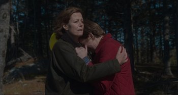Movie still from “The Good House” (2021), directed by Maya Forbes – Two women are hugging in a wooded area; Medium shot, High angle