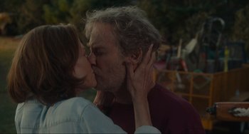 Movie still from “The Good House” (2021), directed by Maya Forbes – A man and a woman kissing in a park setting; Close Up shot, Over the shoulder angle