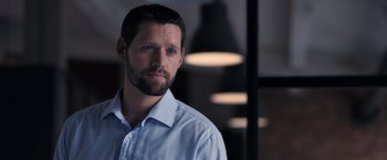 Movie still from “The Good Neighbor” (2022), directed by Stephan Rick – A person wearing a shirt; Close Up shot, Over the shoulder angle