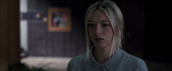 Movie still from “The Good Neighbor” (2022), directed by Stephan Rick – A young woman with blonde hair and a sweater; Close Up shot, Over the shoulder angle