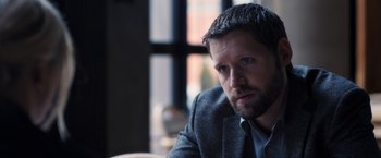 Movie still from “The Good Neighbor” (2022), directed by Stephan Rick – A person wearing a suit and tie; Close Up shot, Over the shoulder angle