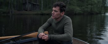 Movie still from “The Good Neighbor” (2022), directed by Stephan Rick – A man sitting in a boat on the water; Medium shot, High angle