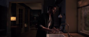 Movie still from “The Good Neighbor” (2022), directed by Stephan Rick – A man is washing his hands in the dark; Medium shot, Over the shoulder angle