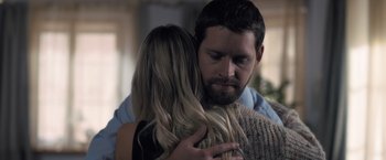 Movie still from “The Good Neighbor” (2022), directed by Stephan Rick – A man and a woman hugging each other in a living room; Close Up shot, Over the shoulder angle