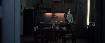 Movie still from “The Good Neighbor” (2022), directed by Stephan Rick – A man standing in a kitchen talking on a phone; Wide shot, Low angle