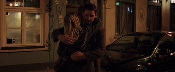 Movie still from “The Good Neighbor” (2022), directed by Stephan Rick – A man and a woman hugging each other outside; Medium shot, Low angle