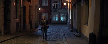 Movie still from “The Good Neighbor” (2022), directed by Stephan Rick – A woman standing on a street at night; Wide shot, Low angle