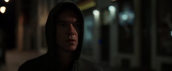 Movie still from “The Good Neighbor” (2022), directed by Stephan Rick – A man in a hooded sweatshirt stares into the camera; Close Up shot, Low angle