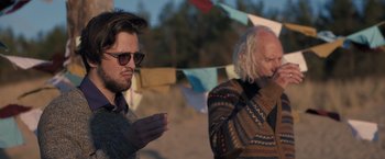 Movie still from “The Good Neighbor” (2022), directed by Stephan Rick – A man and an older man standing next to each other; Medium shot, Over the shoulder angle