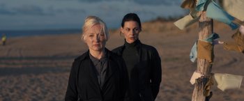 Movie still from “The Good Neighbor” (2022), directed by Stephan Rick – Two women standing next to each other on the beach; Medium shot, Low angle