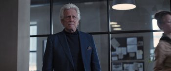 Movie still from “The Good Neighbor” (2022), directed by Stephan Rick – An older man with white hair wearing a blue suit; Medium shot, Low angle