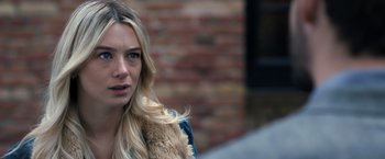 Movie still from “The Good Neighbor” (2022), directed by Stephan Rick – A woman with long blonde hair wearing a blue jacket; Close Up shot, Over the shoulder angle