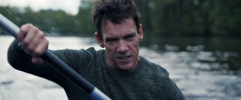 Movie still from “The Good Neighbor” (2022), directed by Stephan Rick – A person paddling a boat on a body of water; Close Up shot, Over the shoulder angle