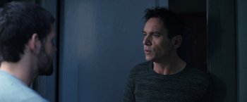 Movie still from “The Good Neighbor” (2022), directed by Stephan Rick – A person wearing a sweater near a wall; Close Up shot, Over the shoulder angle