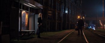 Movie still from “The Good Neighbor” (2022), directed by Stephan Rick – A woman standing on the side of a train track at night; Wide shot, Over the shoulder angle
