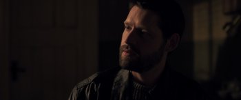 Movie still from “The Good Neighbor” (2022), directed by Stephan Rick – A person with a beard looking to the side; Close Up shot, Over the shoulder angle