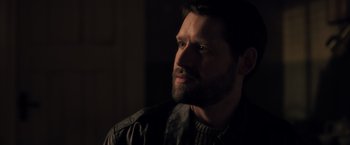 Movie still from “The Good Neighbor” (2022), directed by Stephan Rick – A person with a beard; Close Up shot, Over the shoulder angle