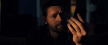 Movie still from “The Good Neighbor” (2022), directed by Stephan Rick – A person using a cell phone; Close Up shot, Low angle