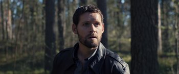 Movie still from “The Good Neighbor” (2022), directed by Stephan Rick – A person wearing a jacket; Close Up shot, High angle