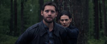 Movie still from “The Good Neighbor” (2022), directed by Stephan Rick – A man and a woman standing next to each other in front of a tree; Medium shot, Over the shoulder angle