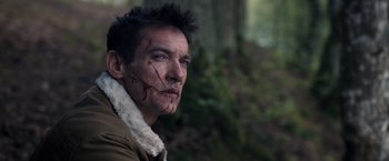 Movie still from “The Good Neighbor” (2022), directed by Stephan Rick – A person with a scar on his face; Close Up shot, Over the shoulder angle